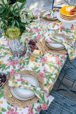 Floral Reverie pink and orange floral cotton tablecloth featuring colourful flowers and botanical foliage on an off-white background. Copy
