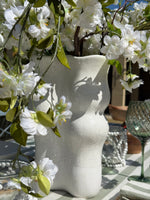 Sierra cream ceramic vase with a sculptural wavy silhouette, half-dipped glaze and raised multicoloured speckled detailing.