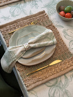 Set of four rectangular natural jute placemats featuring woven olive green stripes.