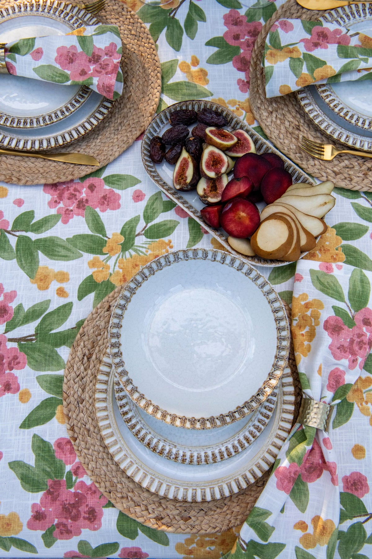Floral Reverie cotton table napkins featuring a colourful pink and orange floral print on an off-white background.