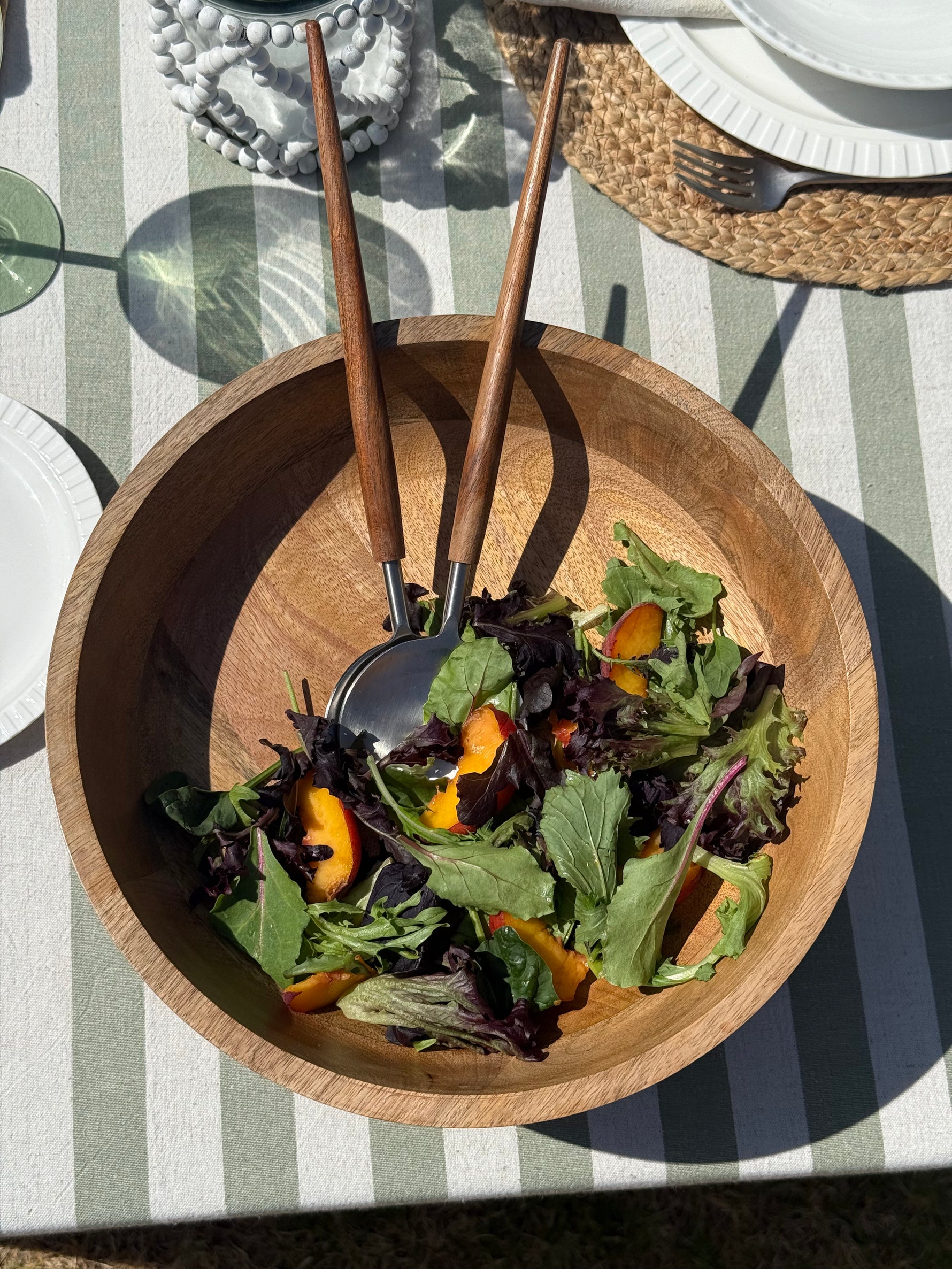 Haven salad server set of 2 featuring natural mango wood handles and stainless steel serving heads.