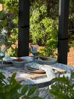 Outdoor dining setup with tableware and glasses on a natural background