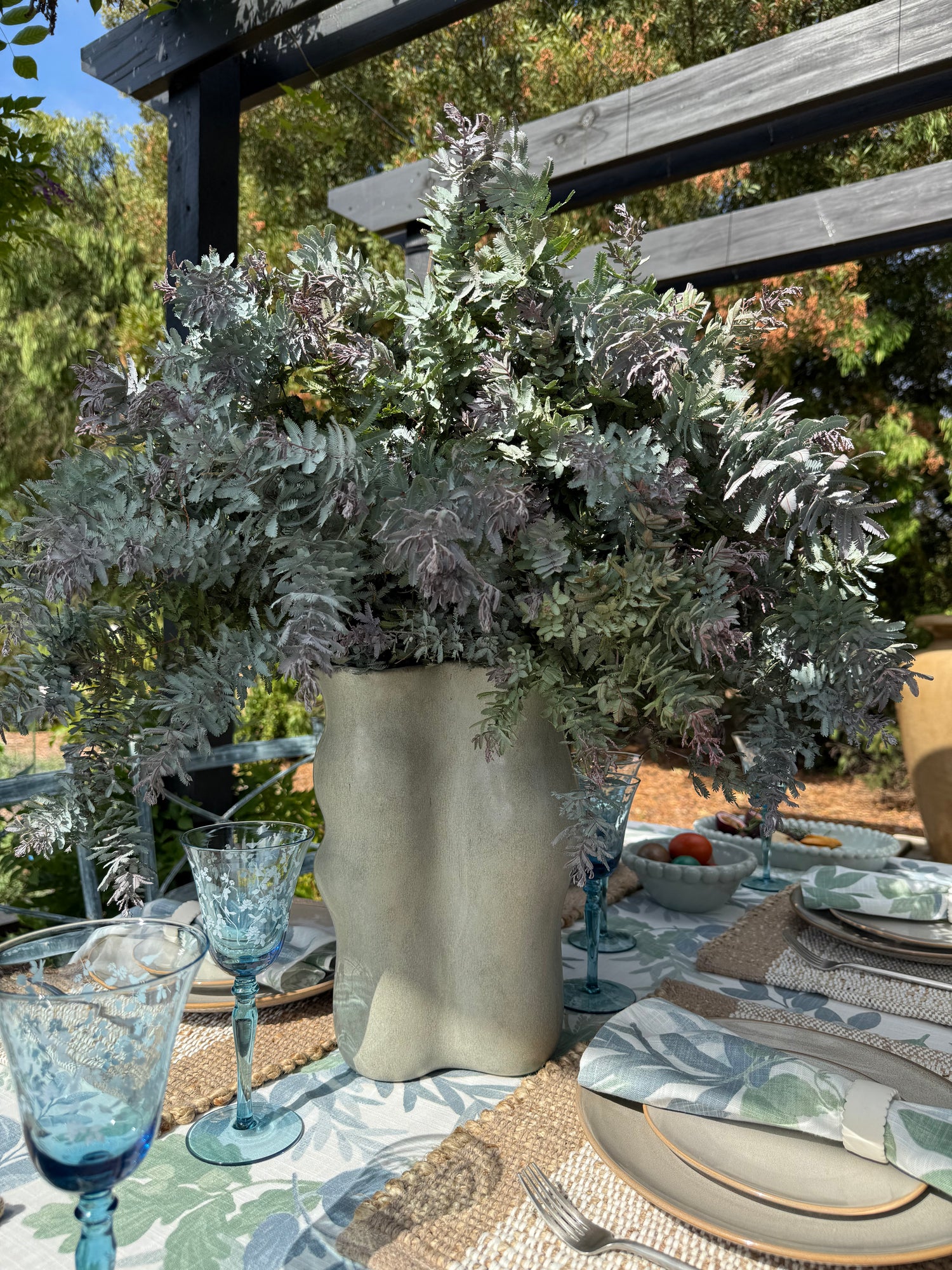 Sierra mineral green ceramic vase with a sculptural wavy silhouette and glossy reactive green glaze.