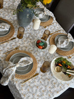 Bluebell Vine cotton tablecloth featuring a blue-grey botanical vine print with soft apricot berries on a light background.