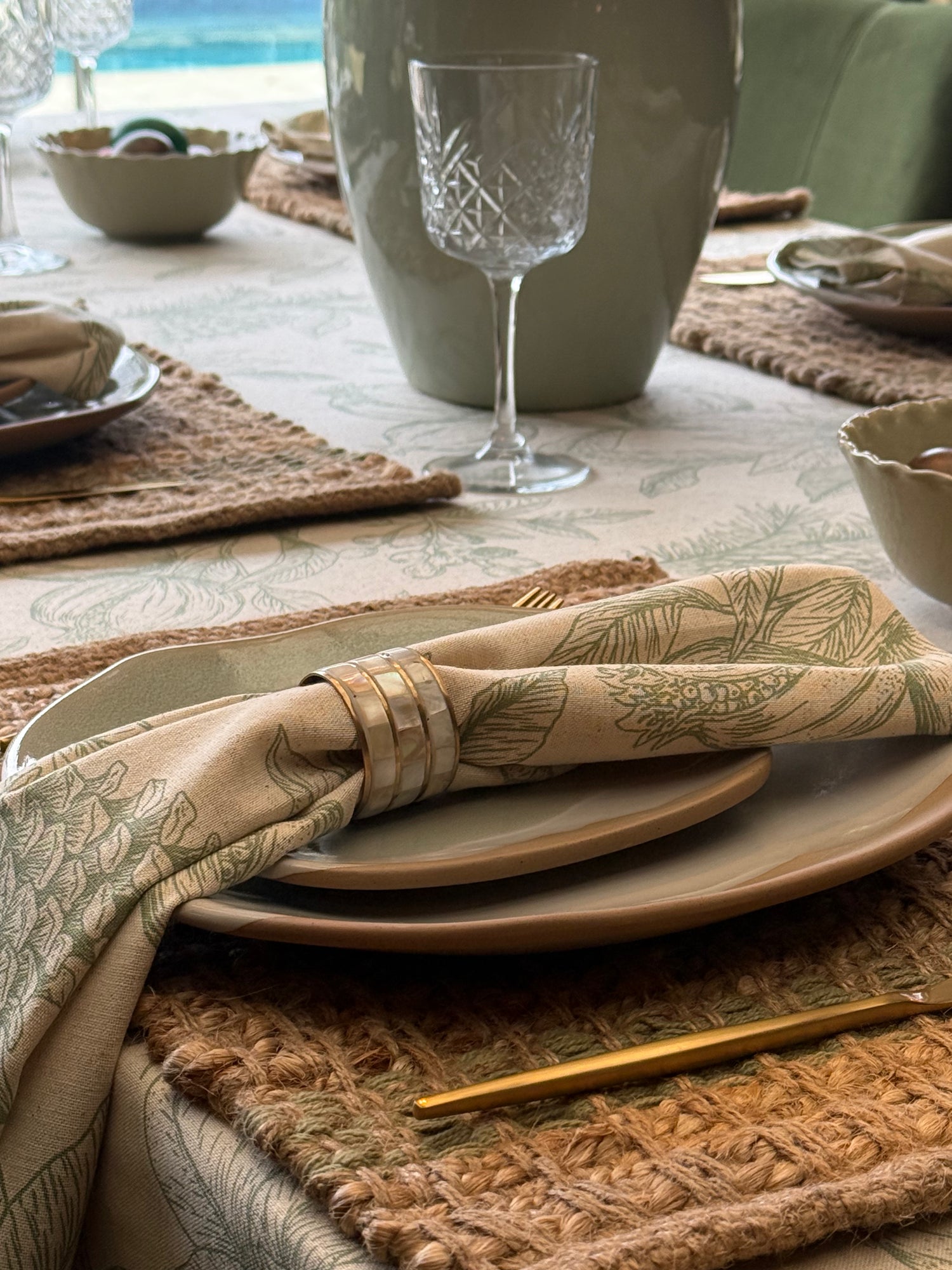 Set of four mother of pearl napkin rings featuring iridescent shell inlays and brushed gold metal detailing.