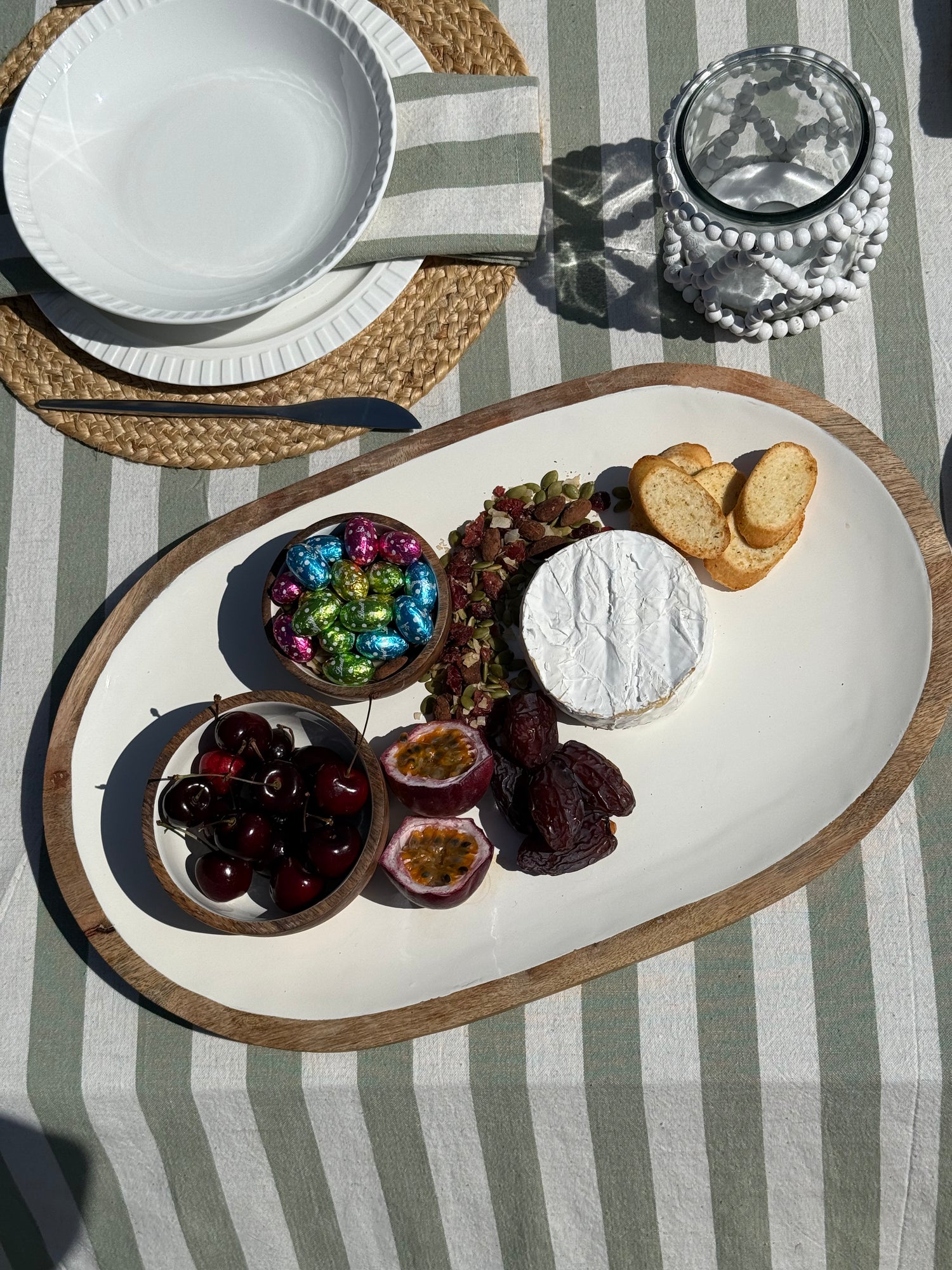 Large oval mango wood serving platter featuring natural timber grain and a smooth white enamel interior.