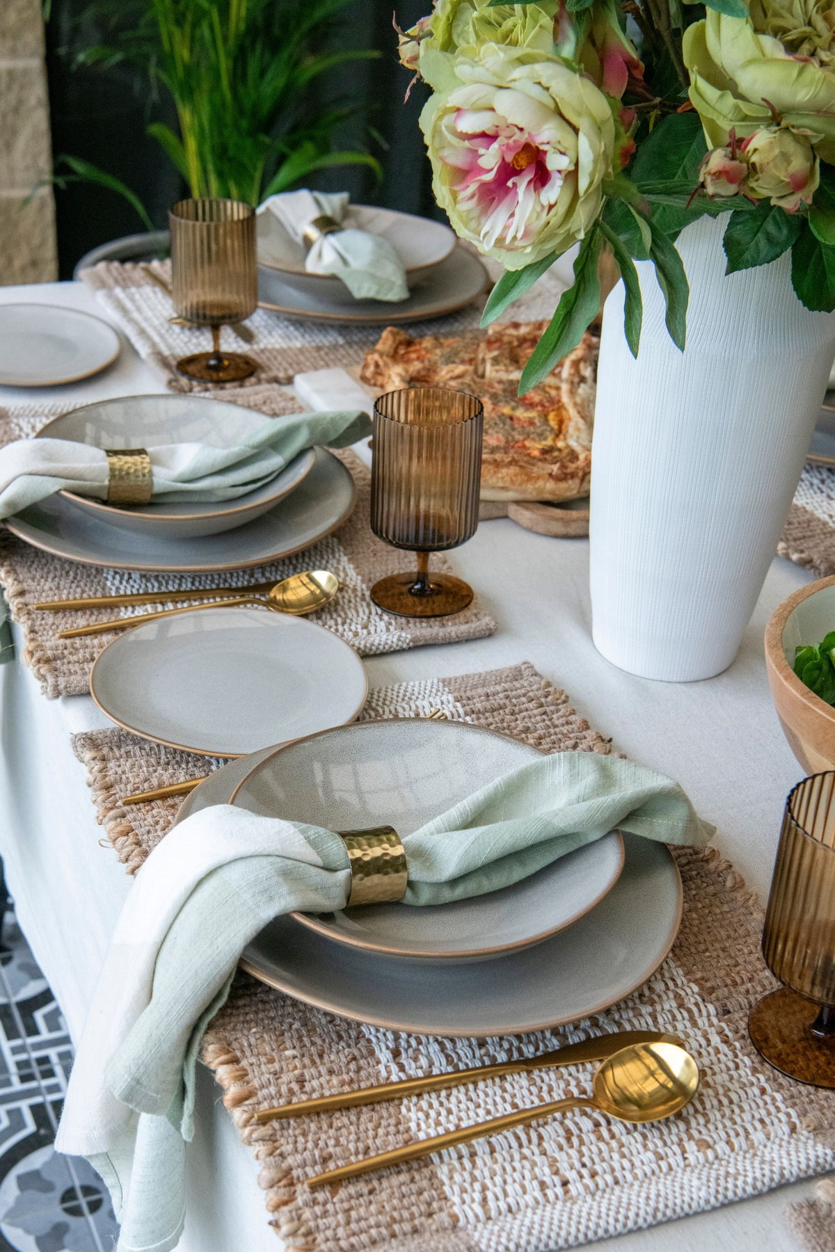 Elegant table setting with plates, napkins, and floral arrangements.